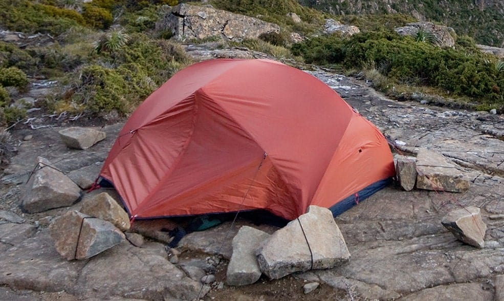 tent with rocks on pegs in wind